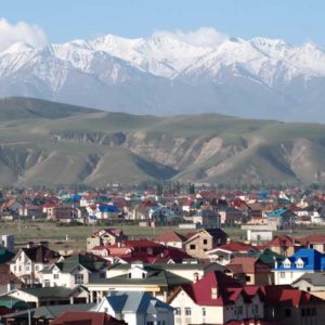 Kyrgyzstan Village with snow capped mountains in the background