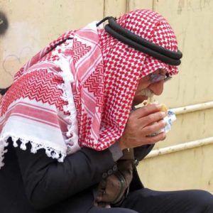 Visit Israel - Palestinian man with red and white head shawl eating his lunch